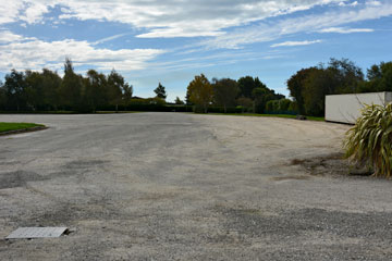 Large gravel parking area behind the main building