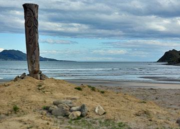 Parking area with a Maori Pou and overlookng the bay